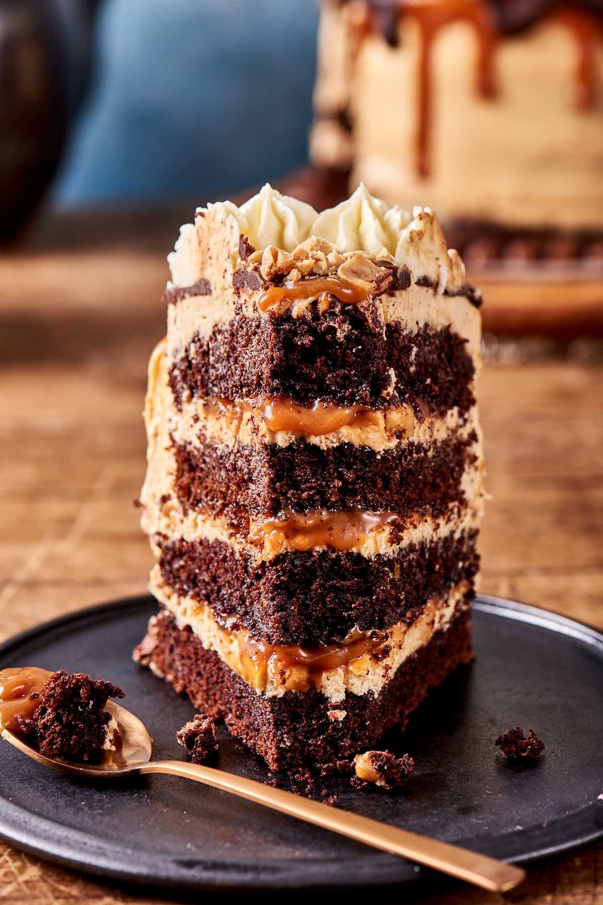 slice of snickers cake on a black plate.